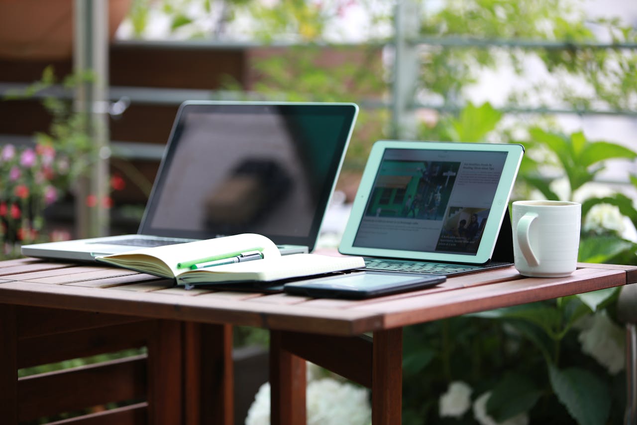 Crafting Captivating Headlines: Your awesome post title goes here A cozy outdoor workspace scene with a laptop, tablet, and mug on a wooden table.